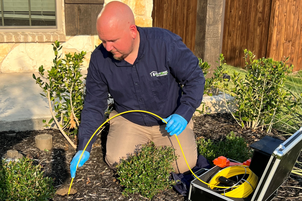 Inspector uses a Sewer Scope at a pipe access to assess the health of a sewer pipe.