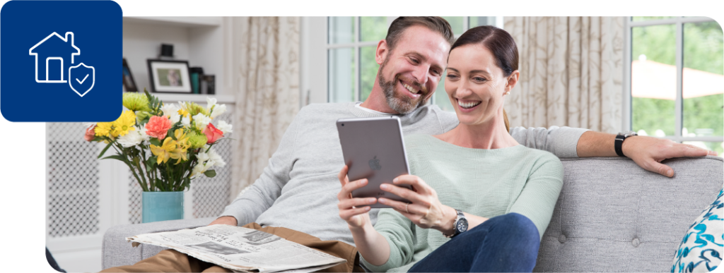 Couple sits on a couch with a tablet and reviews their PTPHomeManual