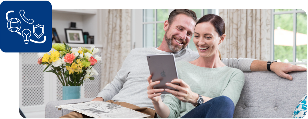 Couple sits on a couch with a tablet and reviews their Pillar to Post Connects.